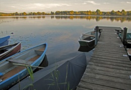 Steg mit Booten am Herbstabend
